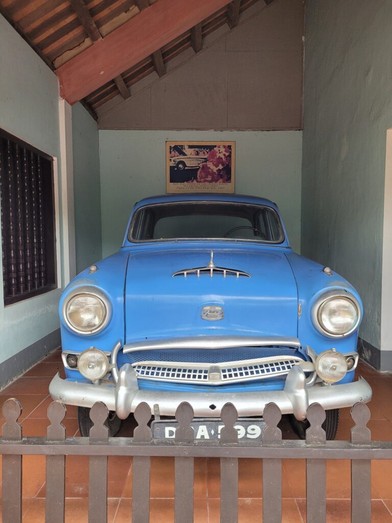 Ein geschichtsträchtiger blauer Oldtimer, der als Exponat in einem Tempel ausgestellt ist.