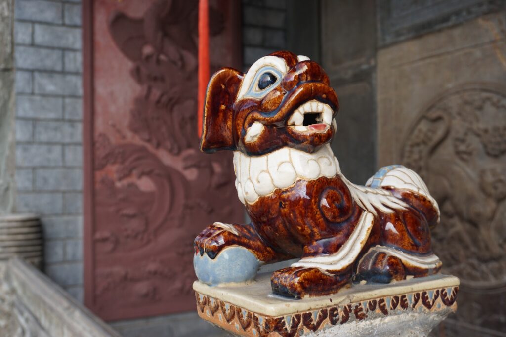 Steinfigur eines roten Drachen in einem chinesischen Tempel.
