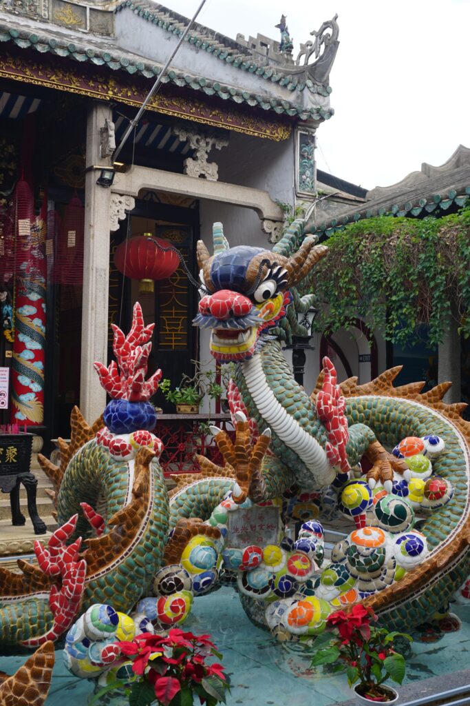 Eine mit bunten Mosaiksteinen dekorierte Drachen-Skulptur in einem chinesischen Tempel.