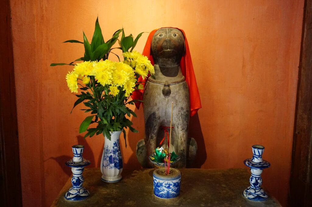 Statue eines Hundes, die den Eingang zur japanischen Brücke in Hoi An bewacht.