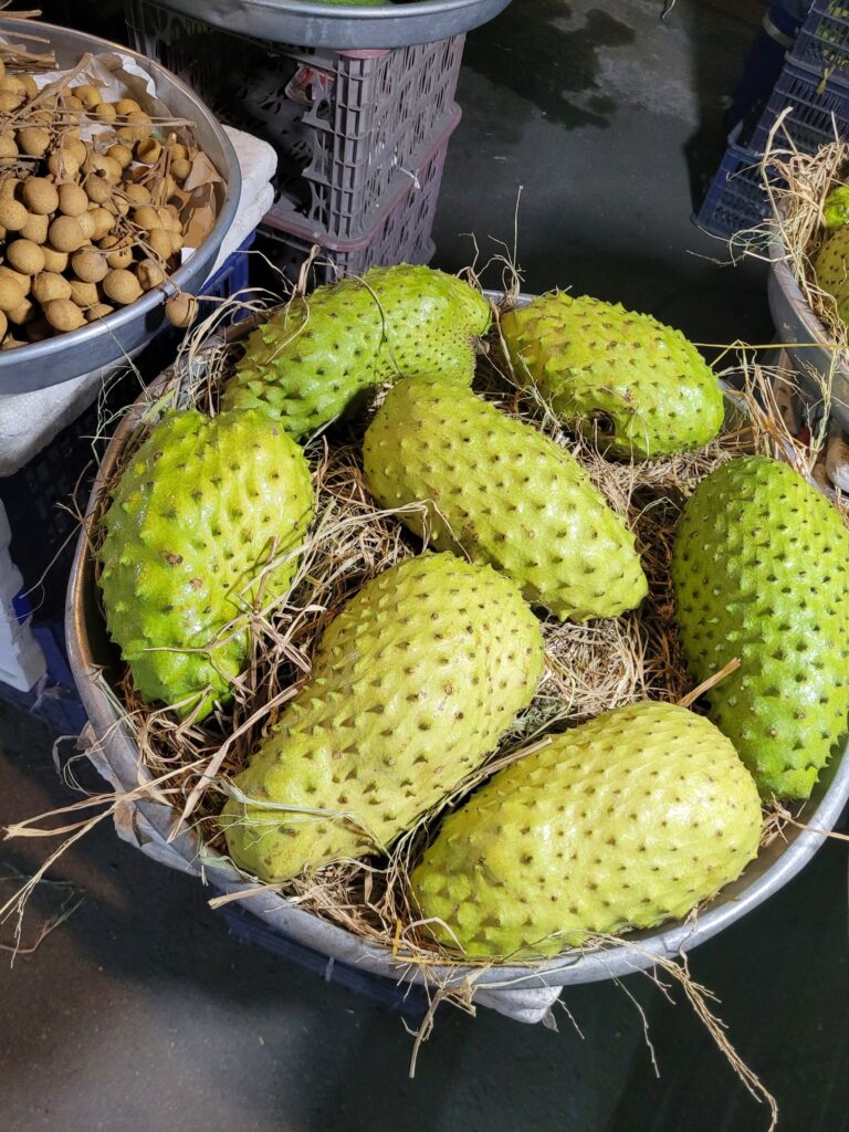 Bittermelonen mit stacheliger, grüner Schale auf einem Markt.