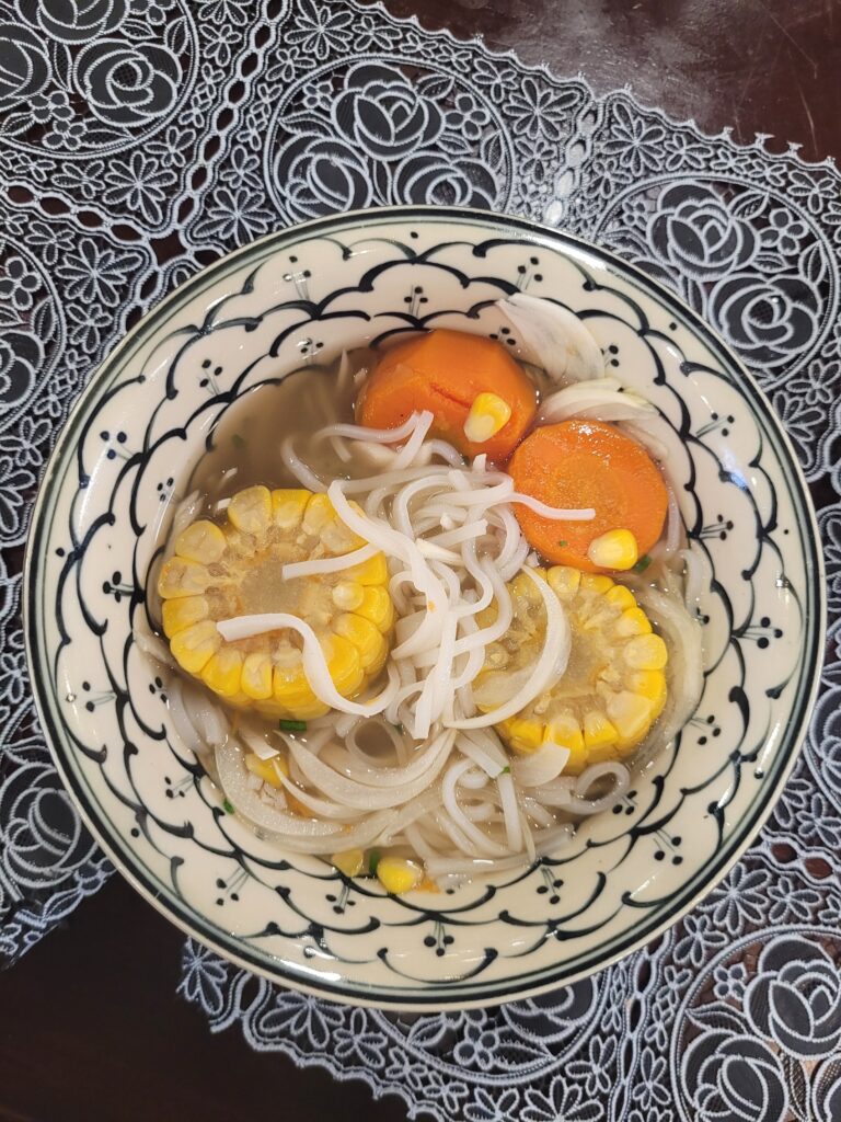Vegetarische Pho-Nudelsuppe mit Mais und Karotten.